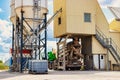 Concrete mixer truck in front of a concrete batching plant, cement factory. Loading concrete mixer truck. Close-up. Delivery of Royalty Free Stock Photo