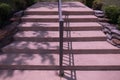 Concrete outdoor steps in staircase with metal railing casting shadow on sunny day Royalty Free Stock Photo
