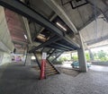 concrete parking lot with behicular stairs crossing at the back, concrete columns