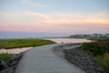 A Concrete Path With an Orange and Blue Sunset Sky Behind It at the North Wildwood Sea Wall in New Jersey Royalty Free Stock Photo