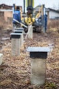 Concrete pile drilling with piling machine, foundation for wooden frame house Royalty Free Stock Photo