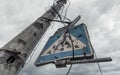 concrete pillar broken by shards and a road sign against a gloomy sky