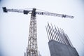 Concrete pillars on industrial construction site. Building of skyscraper with crane, tools and reinforced steel bars Royalty Free Stock Photo