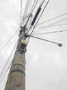 Concrete pole with electric wires and lamp with cloudy sky in the background Royalty Free Stock Photo