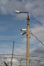 Concrete pole lantern with CCTV cameras against the blue sky. Royalty Free Stock Photo