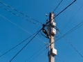 Concrete pole with lantern and lots of electric wires