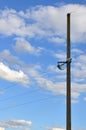 Concrete pole with wires of power line against the background of blue cloudy sk Royalty Free Stock Photo