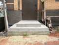 Concrete porch construction: building, pouring a concrete front porch of a brick house to the entry doors threshold level