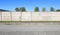 Concrete precast compound wall at the road side. Sidewalk and road in front, trees on behind Royalty Free Stock Photo