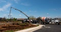 Concrete pump at a house foundation with cement mixers