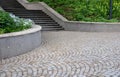 concrete retaining wall at the large staircase in the park the flowerbed area is planted with rich greenery of perennials granite
