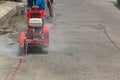 Concrete Road Cutters with worker. Worker using diamond saw blade machine cutting concrete road at construction site. Concrete cut Royalty Free Stock Photo