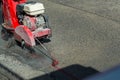 Concrete Road Cutters with worker. Worker using diamond saw blade machine cutting concrete road at construction site. Concrete cut Royalty Free Stock Photo