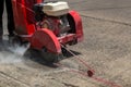 Concrete Road Cutters with worker. Worker using diamond saw blade machine cutting concrete road at construction site. Concrete cut Royalty Free Stock Photo