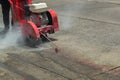 Concrete Road Cutters with worker. Worker using diamond saw blade machine cutting concrete road at construction site. Concrete cut Royalty Free Stock Photo