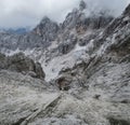 Concrete sewer pipe coming out of the shelter and falling deeply in a mountain slope, Italy Dolomites