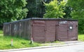 Concrete shed gray with brown wooden gates in the courtyard of an apartment building