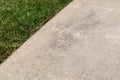 Concrete sidewalk with light staining set diagonally alongside green grass, well tended Royalty Free Stock Photo