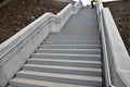Concrete staircase with massive side panels. railings are retaining walls sunk beneath the terrain. double stainless steel handle