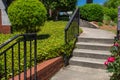 Concrete stairs and curving walkway bordered by brick retaining wall and groundcover