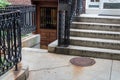 Concrete stairs going up and down, elaborate wrought iron railings and manhole cover Royalty Free Stock Photo