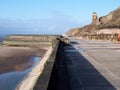 Concrete stairs on seawall in blackpool with the beach at low tide in sunlight with the old boat pool and tower in the difference Royalty Free Stock Photo