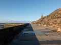 Concrete stairs on seawall in the cliffs area blackpool with the beach at low tide in sunlight with the old boat pool and tower in Royalty Free Stock Photo