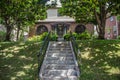 Concrete steps up to charming house on hill under magnolia trees - selective focus on steps