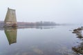 Concrete support of the blown up bridge on the river in damp foggy weather. Consequences of the war. Background