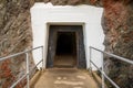 Concrete walking path leading into dark tunnel into mountain side Royalty Free Stock Photo