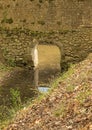 Concrete wall with an arch through the creek. wall with moss