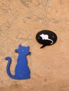 a concrete wall with a blue wooden cat thinking of a white mouse, funny blue cat with a speech bubble with a white mouse in a