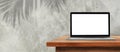 Laptop with empty blank screen on wooden top table with concrete wall in background. Royalty Free Stock Photo