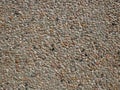 Concrete wall with sandy shapeless stones inlaid into it Royalty Free Stock Photo