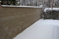 Concrete wall from texture blocks. high dividing noise wall of the yard. The wall is equipped with a sheet metal roof, which preve