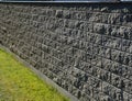 Concrete wall from texture blocks. high dividing noise wall of the yard. The wall is equipped with a sheet metal roof, which preve