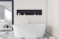 Concrete white and blue bathroom interior with a grey marble floor  a bathtub  a double sink  ladder and a loft window city view. Royalty Free Stock Photo