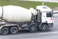 Concrete white mixer truck rides on city highway
