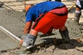 Concrete worker  screeding and leveling the wet mud Royalty Free Stock Photo