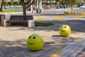 Concrete yellow restrictive spheres with funny smiley face indicating entry to pedestrian zone. Traffic car blocker.