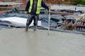 Concreter checking level of the concrete using laser level and staff as he pour ground floor slab of new residential house Royalty Free Stock Photo