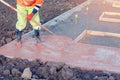 Concreter spreading poured concrete with rake or spazzle A construction worker is levelling tinted concrete in formwork Royalty Free Stock Photo