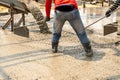 Concreters level on the concrete mix with rubber shoes. Royalty Free Stock Photo