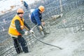 Concreting work. Two concreter with vibration tool Royalty Free Stock Photo