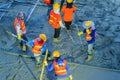 Concreting workers are leveling poured liquid concrete on a steel reinforcement to form strong floor slabs.