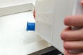 Condensate container from the dryer, a woman drains the accumulated water after drying clothes in the dryer.