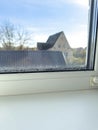 Condensation Droplets on Window Sill with Blurry View of House and Tree on Sunny Day Royalty Free Stock Photo