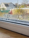 Condensation Droplets on Window Sill with Blurry View of House and Tree on Sunny Day Royalty Free Stock Photo