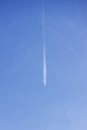 Condensation light line in the sky from aircraft. Trail of the plane on blue background. Airplane with white trace in clear sky. h