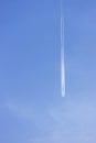 Condensation light line in the sky from aircraft. Trail of the plane on blue background. Airplane with white trace in clear sky. h